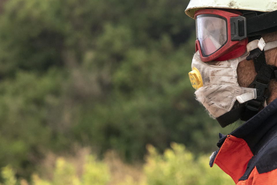 A forest firefighter works in a wildfire in Estepona, Spain, Thursday, Sept. 9, 2021. Nearly 800 people have been evacuated from their homes and road traffic has been disrupted as firefighting teams and planes fight a wildfire in southwestern Spain. (AP Photo/Sergio Rodrigo)