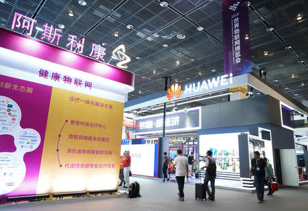 The booth of the British pharmaceutical company AstraZeneca is seen next to Huawei's booth, at the World Internet of Things Expo in Wuxi, Jiangsu province, China September 14, 2018. Picture taken September 14, 2018. REUTERS/Stringer/Files