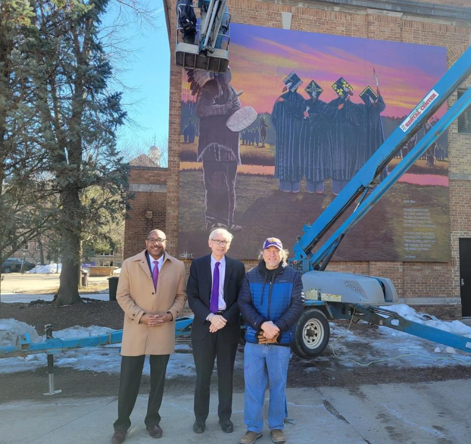 Pictured left to right are UWSP Chancellor Thomas Gibson, Wisconsin Gov. Tony Evers and mural artist Christopher Sweet (Ho-Chunk) during the installation of Sweet's mural at UWSP.