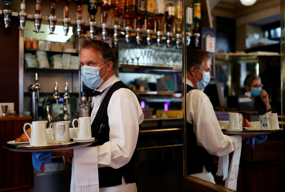 Image: A waiter wearing a face mask serves at Cafe de Flore, as restaurants and cafes reopen following the coronavirus disease (COVID-19) outbreak, in Paris, France (Christian Hartmann / Reuters)