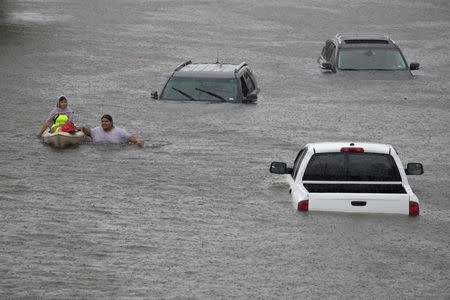 Jesus Rodriguez rescues Gloria Garcia after rain from Hurricane Harvey flooded Pearland, in the outskirts of Houston, Texas, U.S. August 27, 2017. REUTERS/Adrees Latif