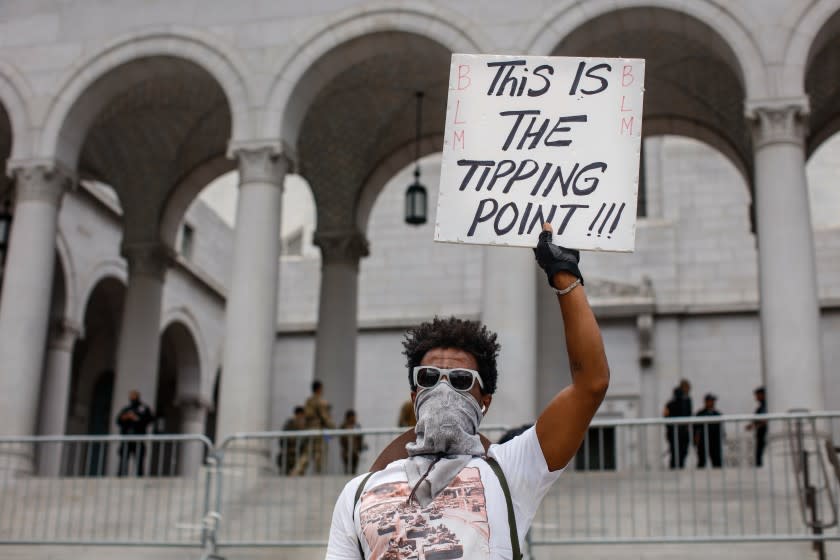 LOS ANGELES, CA - JUNE 05: Mek Bitul held up a sign with the words, "This Is The Tipping Point!!!" in front of City Hall, joining nearly 1,000 people gathered to protest the death of George Floyd and in support of Black Lives Matter, in downtown, Los Angeles, CA, on Friday, June 5, 2020. (Jay L. Clendenin / Los Angeles Times)