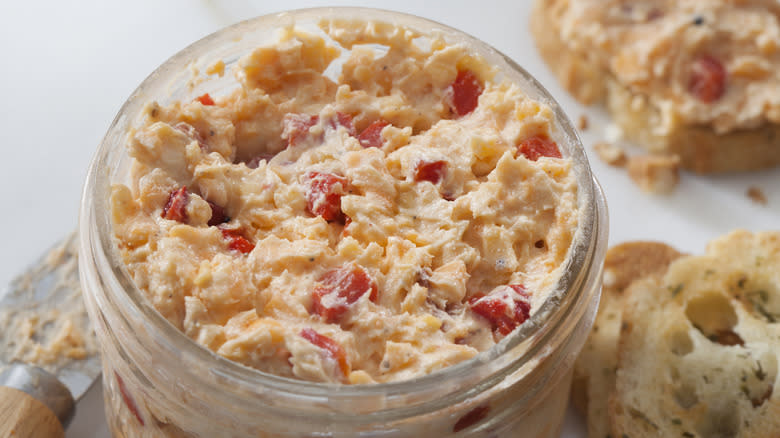 Jar of pimento cheese next to bread