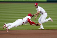 St. Louis Cardinals third baseman Nolan Arenado, left, dives but is unable to reach a single by Colorado Rockies' Garrett Hampson as Cardinals shortstop Paul DeJong, right, backs up the play during the first inning of a baseball game Friday, May 7, 2021, in St. Louis. (AP Photo/Jeff Roberson)