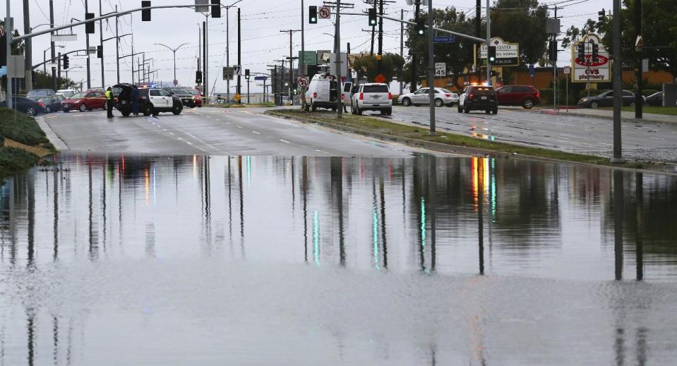 La Cienega Boulevard, a major arterial route in the Westchester district of Los Angeles, is flooded, likely due to blocked storm drains Friday, Dec. 16, 2016. A late fall storm has drenched California, causing some mud flows, roadway flooding and traffic snarls as it takes parting shots at the south end of the state. (AP Photo/Reed Saxon)