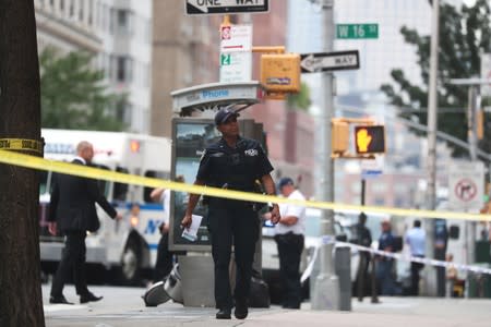 A NYPD officer is seen near West 16th Street and Seventh Avenue as police were investigating suspicious packages in Manhattan