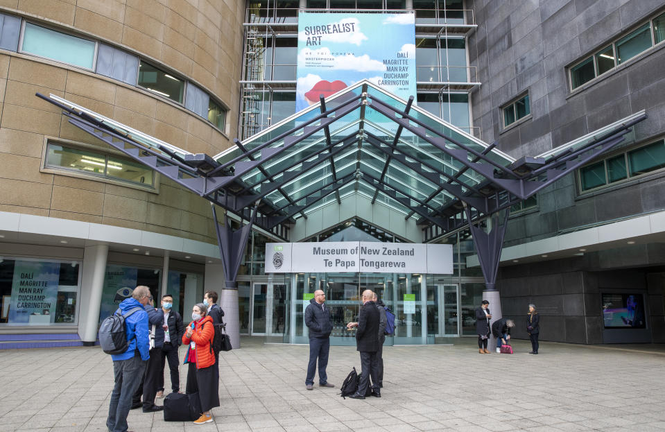 Visitors stand outside Te Papa museum in Wellington, New Zealand, Wednesday, June, 23, 2021. After enjoying nearly four months without any community transmission of the coronavirus, New Zealanders were on edge Wednesday after health authorities said an infectious traveler from Australia had visited over the weekend. (Mark Mitchell/NZ Herald via AP)