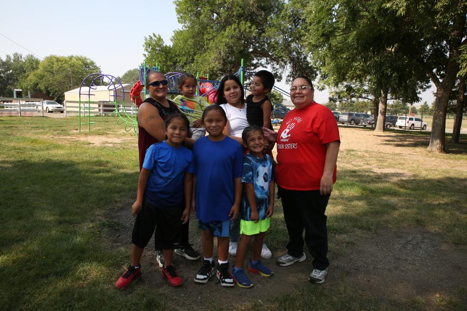 Jessica (far left) and Natasha (far right) Eagle Star pose for a photo with their children at the Winner City Park on Tuesday, Aug. 29, 2023. Four of the children are adopted and the couple serves as guardians for two of the children. Jessica’s two biological, adult children are not pictured.