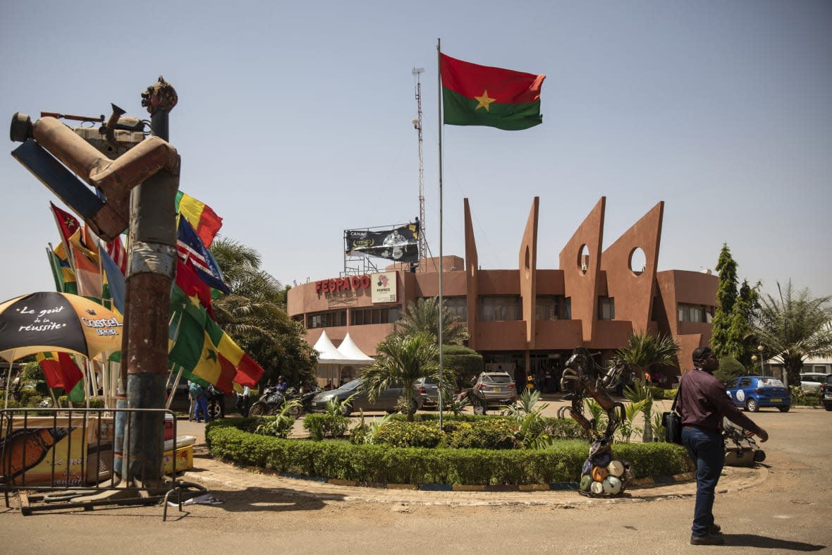 A man walks past the entrance of the headquarters of the FESPACO (Pan-African Film and Television Festival) in Ouagadougou, Burkina Faso, Friday, Feb. 24, 2023. Most film festivals can be counted on to provide entertainment, laced with some introspection. The weeklong FESPACO that opens Saturday in violence-torn Burkina Faso’s capital goes beyond that to also offer hope, and a symbol of endurance. (AP Photo/Sophie Garcia)