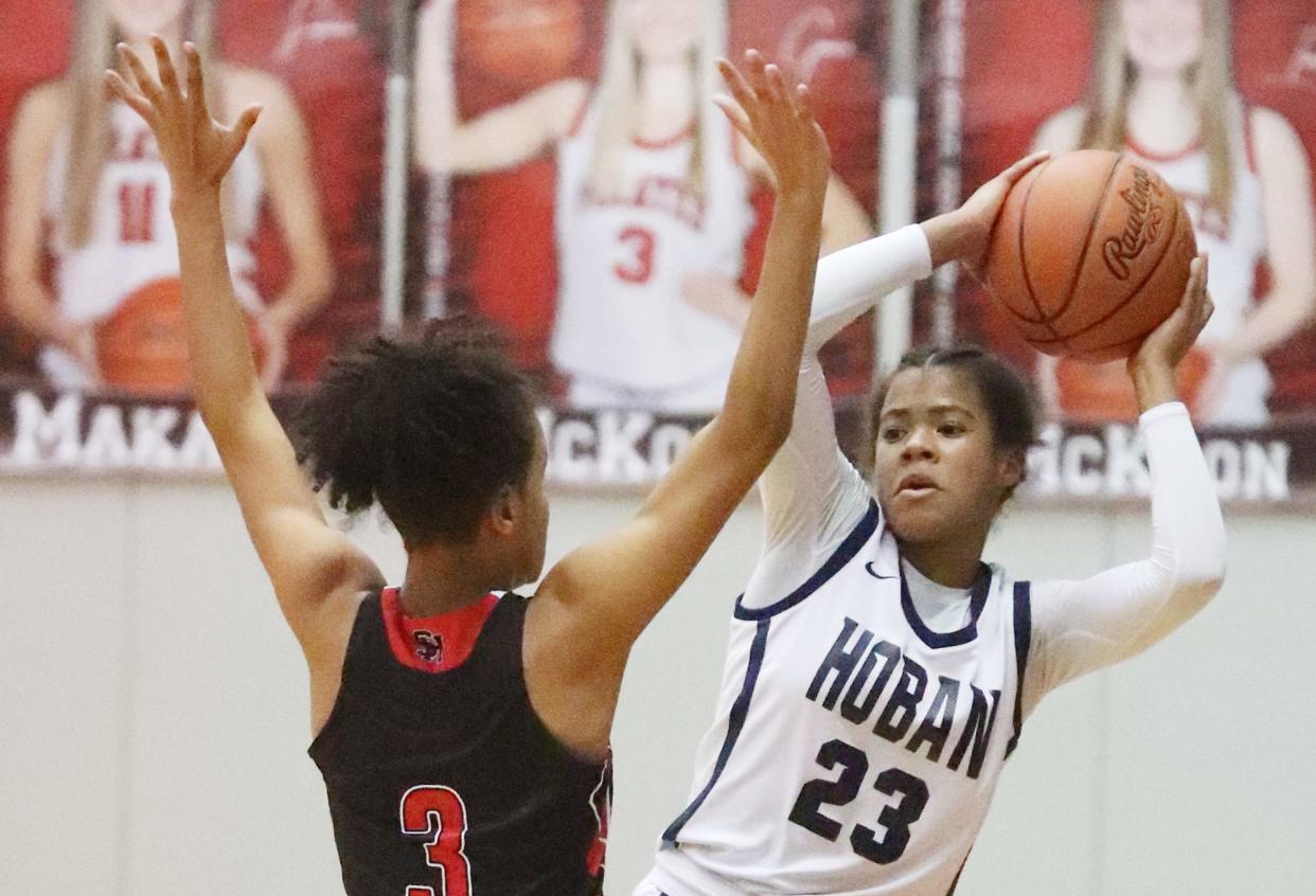 Hoban's Maya Pooler looks to pass around Shaker Heights' Azaria Bryant-Franklin in a Division I district semifinal Feb. 21, 2023, at Perry High School.