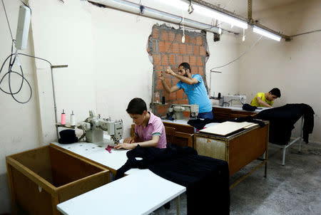 Muhamed (L), a Syrian refugee boy, and his older brother Mustafa (R) work at a small textile factory in Istanbul, Turkey, June 24, 2016. REUTERS/Murad Sezer