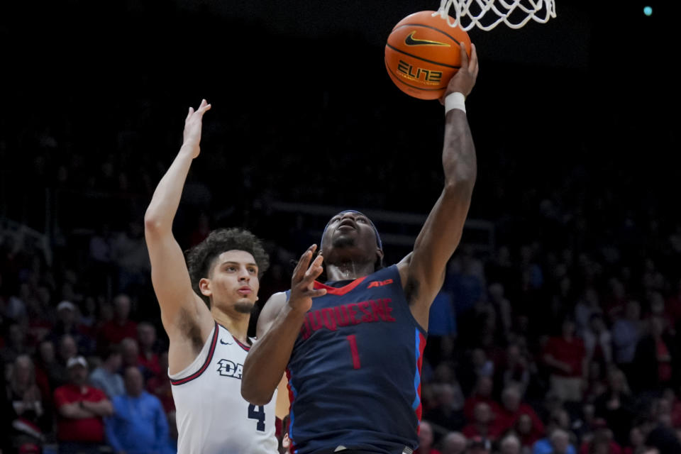 Duquesne guard Jimmy Clark III (1) drives to the basket against Dayton guard Koby Brea (4) during the first half of an NCAA college basketball game, Tuesday, Feb. 13, 2024, in Dayton, Ohio. (AP Photo/Aaron Doster)