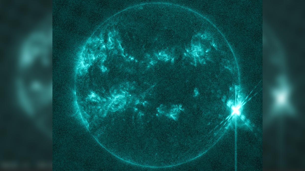  An image of the sun showing a large bright white spot on its bottom-right. 