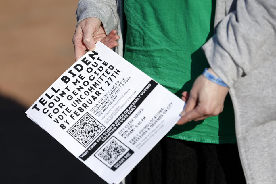 A person holds a flyer reading: Tell Biden, Count me out for genocide, vote uncommitted by February 27th