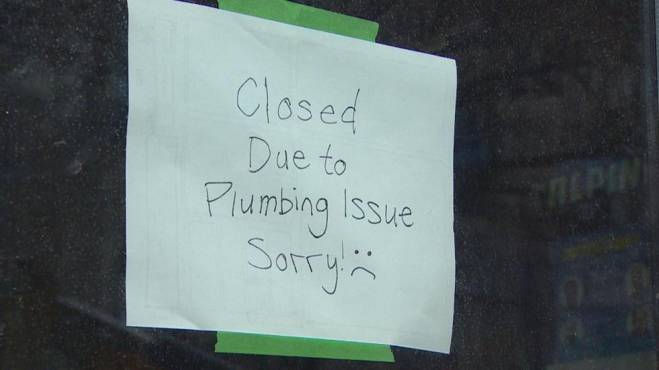 A note posted up on the window of The Alpine restaurant in Toronto's Junction neighbourhood that reads 'Closed due to plumbing issue. Sorry.'