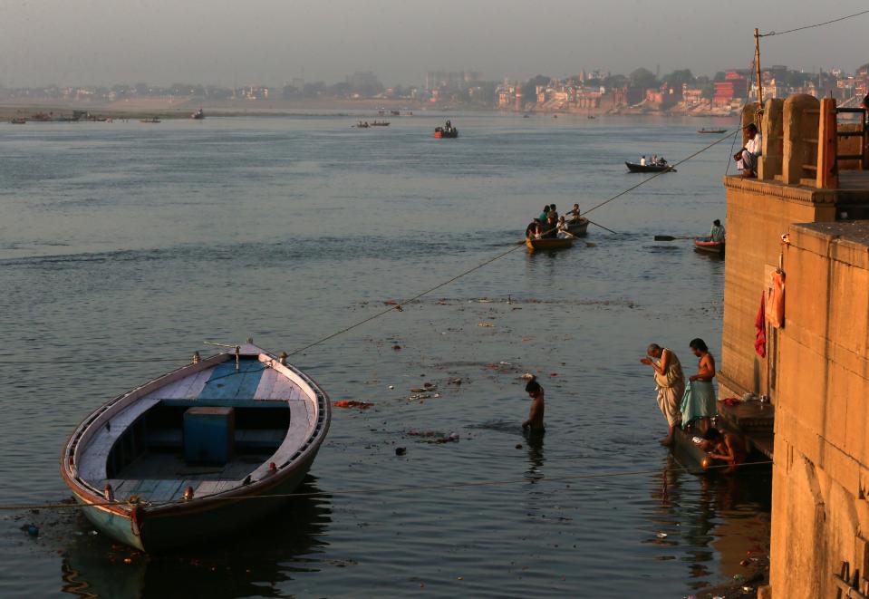 In this Tuesday, April 1, 2014, photo, Indian devotees pray and take dip on the banks of the river Ganges, in Varanasi, India. For tens of millions of people, the city of Varanasi, on the banks of the river Ganges, is a place of pilgrimage, where devout Hindus believe they earn instant salvation. But in recent weeks Varanasi also has become the noisy battleground for India's most-watched contest in its national elections: Two of the country’s most prominent politicians are facing off in a contest for the city’s sole parliamentary seat. (AP Photo /Manish Swarup)