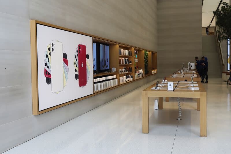 FILE PHOTO: Staff stand in an Apple store with no customers after it was closed on Regents Street in London