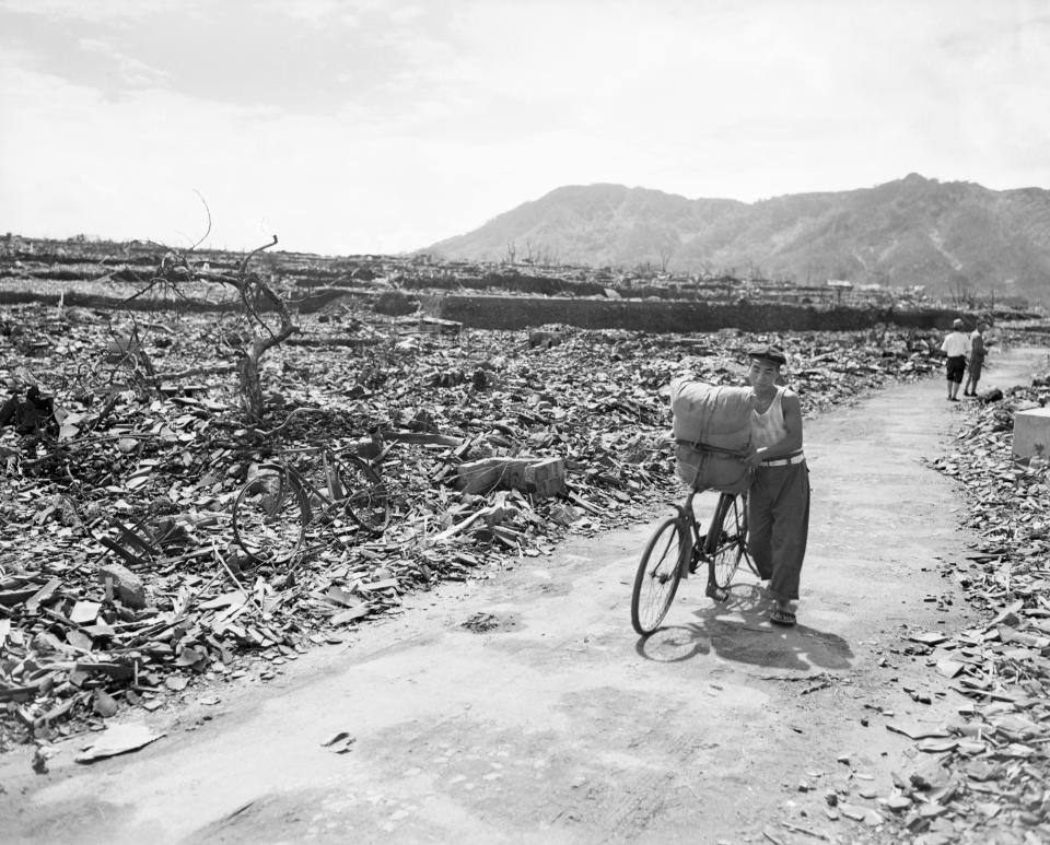 A Japanese civilian pushes his loaded bike down a path which has been cleared of the rubble. On either side of the path debris, twisted metal, and gnared tree stumps fill the area in Nagasaki on Sept. 13, 1945. This is in the center of the devasted area. (Photo: Bettmann/Getty Images)