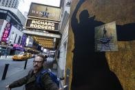 Theatre personnel leave the Richard Rodgers theatre that is closed due to COVID-19 concerns in Times Square, Thursday, March 12, 2020, in New York. New York City Mayor Bill de Blasio said Thursday he will announce new restrictions on gatherings to halt the spread of the new coronavirus in the coming days. For most people, the new coronavirus causes only mild or moderate symptoms. For some it can cause more severe illness. (AP Photo/John Minchillo)