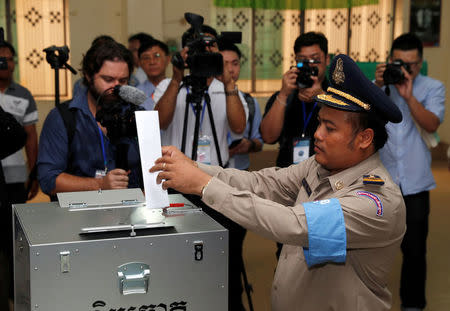 A policeman working as election security casts his vote during a general election in Takhmao, Kandal province, Cambodia July 29, 2018. REUTERS/Darren Whiteside