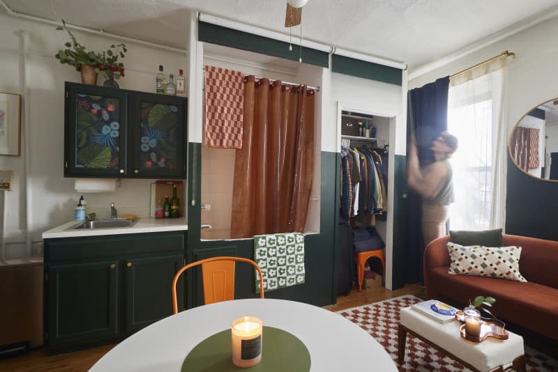 Dweller reveals closet area in multi-use studio apartment.