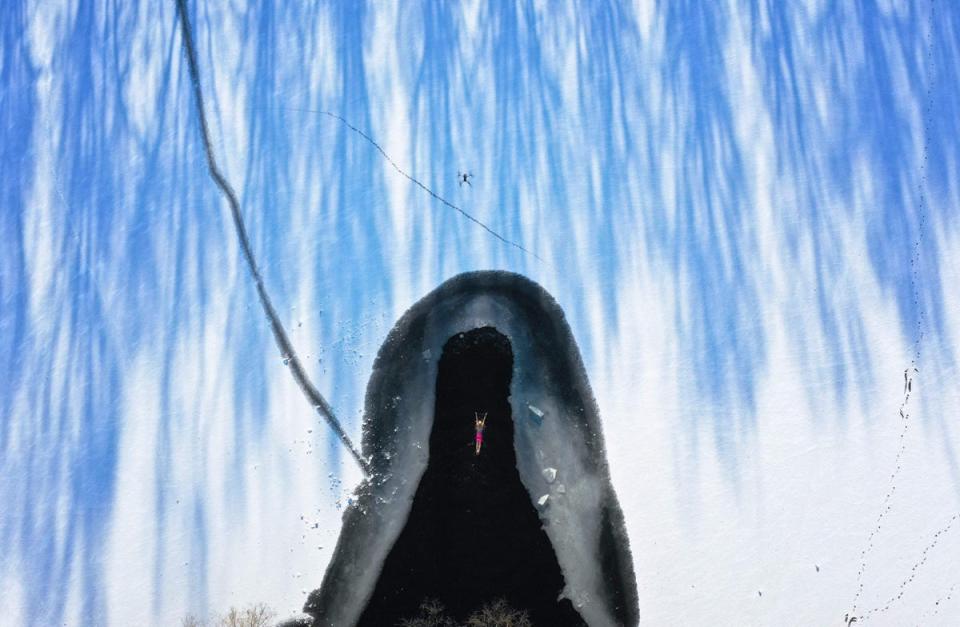 3 December 2022: A winter swimming enthusiast swimming in a partly frozen lake after snowfall in Shenyang, in northeastern China’s Liaoning province (AFP/Getty)