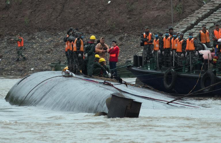 Rescue workers are seen on the hull of a capsized passenger ship Dongfangzhixing or "Eastern Star" in the Yangtze river at Jianli in China's Hubei province on June 3, 2015