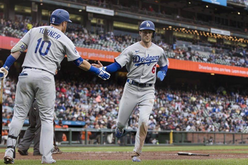 Los Angeles Dodgers' Trea Turner is congratulated by Justin Turner after he scored against the San Francisco Giants during the sixth inning of a baseball game in San Francisco, Sunday Sept. 18, 2022. (AP Photo/John Hefti)