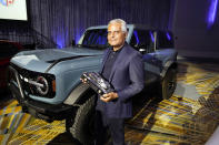 Kumar Galhotra, Ford President of the Americas and International markets group poses next to the Bronco off-road SUV, Tuesday, Jan. 11 2022 in Detroit. For the second year in a row, vehicles from Ford Motor Co. took two of the three North American Car, Truck and Utility of the Year awards. The company's Maverick compact pickup won truck of the year, while its Bronco off-road SUV earned the utility of the year. Honda's redesigned Civic compact car won the car of the year. (AP Photo/Carlos Osorio)