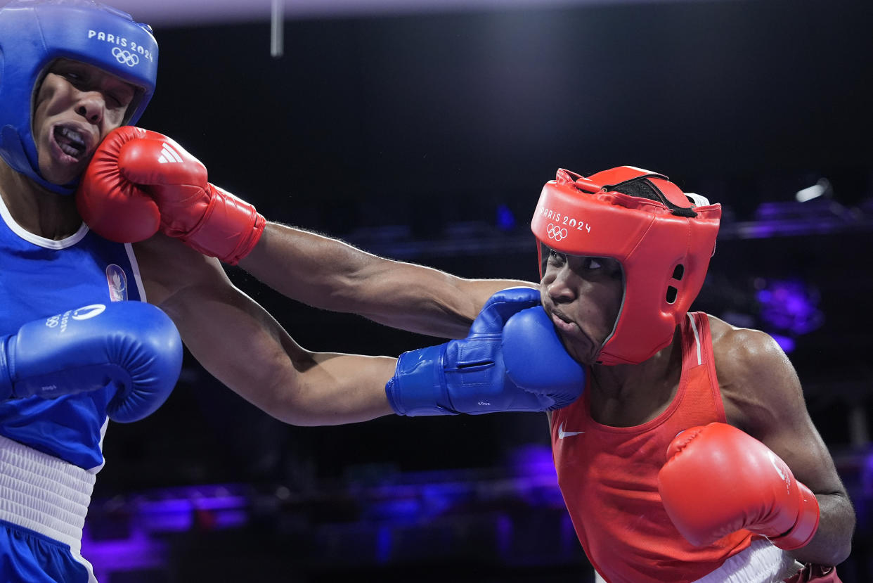 The Refugee Olympic Team's Cindy Ngamba hits France's Davina Michel in the women's 75 kg quarterfinal boxing match at the Summer Olympics on Sunday.