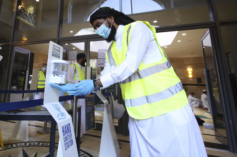 A Muslim man uses hand sanitizer at the Bradford Grand Mosque as Muslims gathered for Eid al-Adha prayers, in Bradford, West Yorkshire, England, Friday July 31, 2020. Britain’s health secretary has defended a decision to reimpose restrictions on social life in a swath of northern England, saying it was important to keep ahead of the spread of COVID-19. The affected region has a large Muslim population, and the restrictions come prior to the Eid al-Adha holiday starting on Friday. (Danny Lawson/PA via AP)