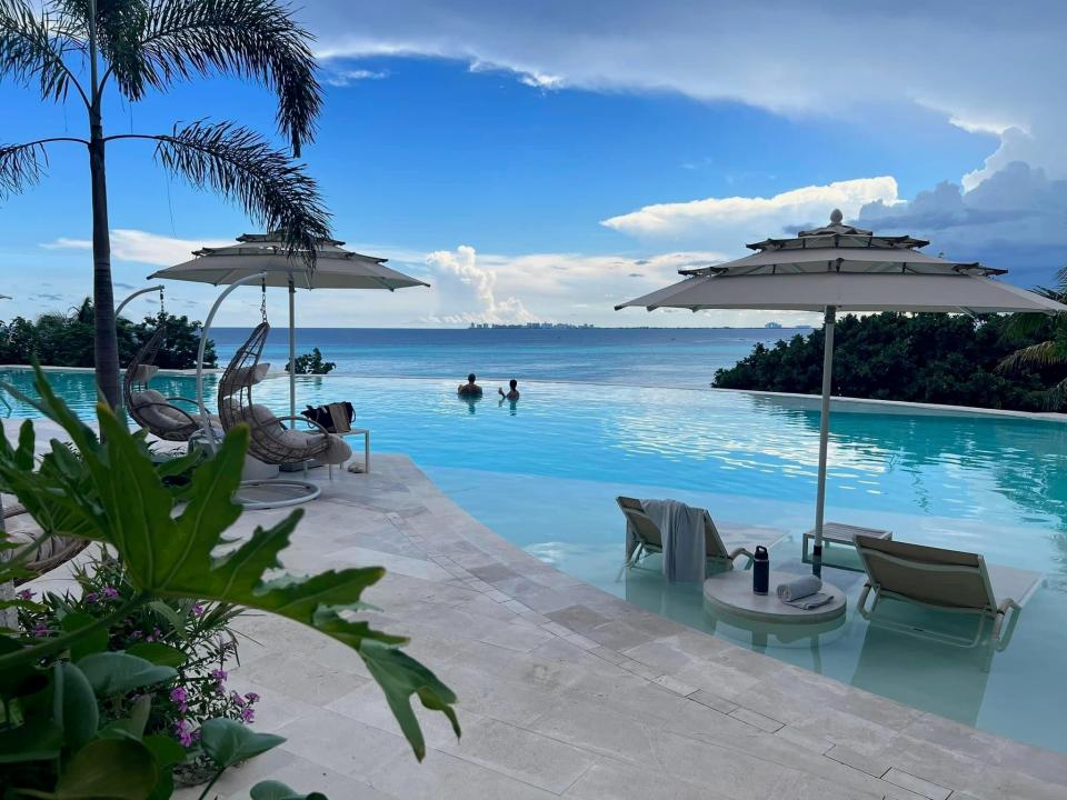 fancy infinite pool with swing chairs and underwater loungers looking the ocean