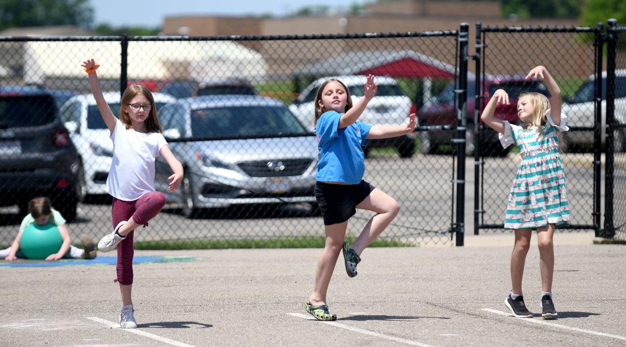 Northwest Primary School second-graders Rylinn Wirtzberger, from left, Mila Swank and Lena Herron, dance their way through recess Tuesday, May 24, 2022, at the school.