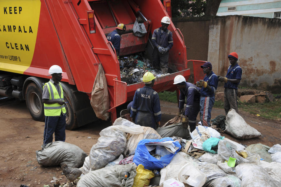 In this photo of Wednesday, July 10, 2019, workers of Kampala Capital City Authority remove garbage under a campaign encouraging people to keep their neighbourhood clean, in Makindye Lukuli area of Kampala, Uganda. Africa faces a population boom unmatched anywhere in the world, with millions of people moving to fast-growing cities but the decades-old sanitation facilities are crumbling under the pressure. (AP Photo/Ronald Kabuubi)