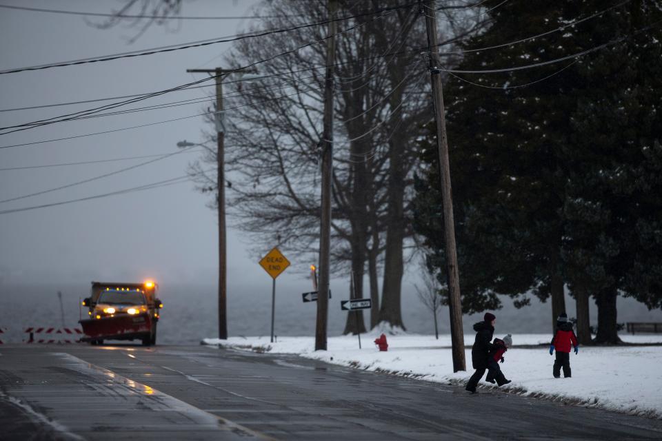 People make their way across Vansant Avenue as an Ocean County snowplow clears the roads of ice and snow. A mix of rain, snow, and sleet falls throughout the Jersey Shore as day breaks. 
Island Heights, NJ
Tuesday, January 16, 2024