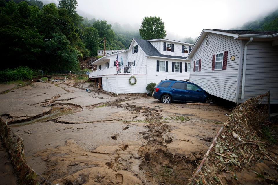 A displaced home sits over mud and a car in Whitewood, Virginia on Thursday, the result of dangerous flooding (AP)