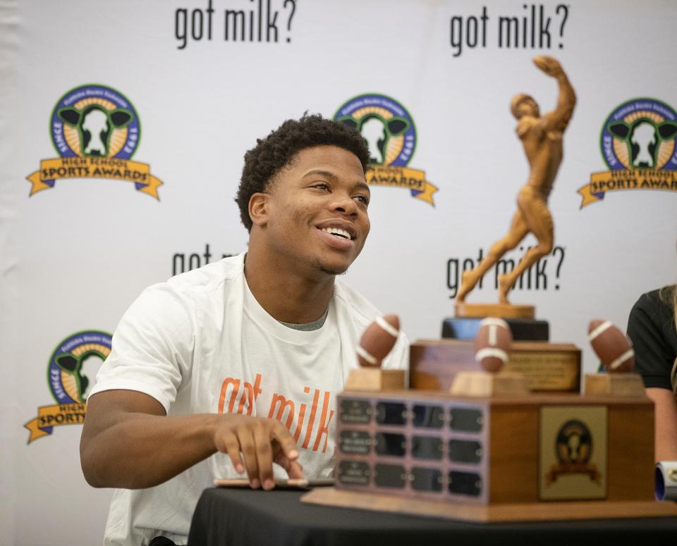 Lakeland High School football player Demarkcus Bowman sits behind his Florida Dairy Farmers 2019 Mr. Football trophy during a ceremony at the school in Lakeland Fl. , Wednesday February 5 2020. ERNST PETERS/THE LEDGER
