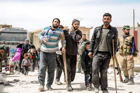 People are seen evacuated by Syrian forces from eastern Ghouta in Saqba, Syria, March 18, 2018. SANA/Handout via REUTERS