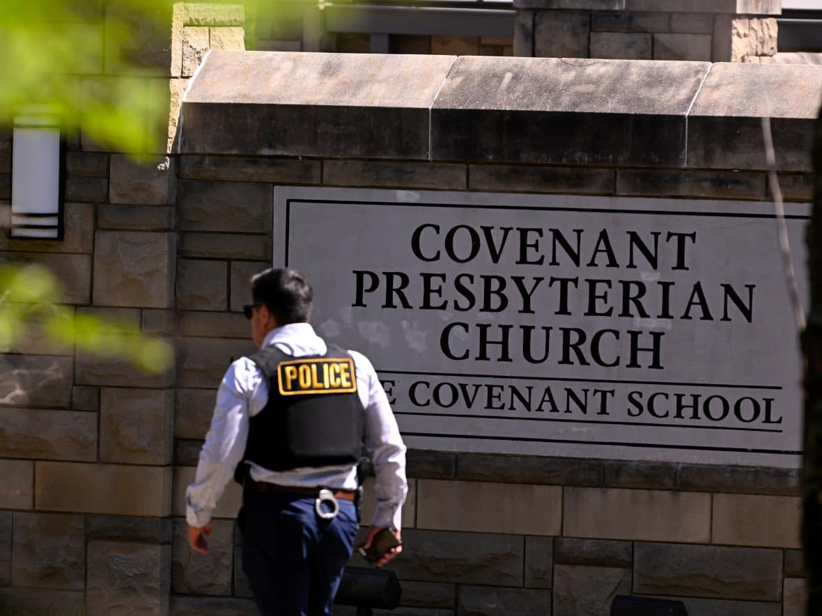 A police officer walks by an entrance to The Covenant School after a shooting in Nashville, Tenn. on Monday, March 27, 2023.  (AP Photo/John Amis) (John Amis/The Associated Press - image credit)