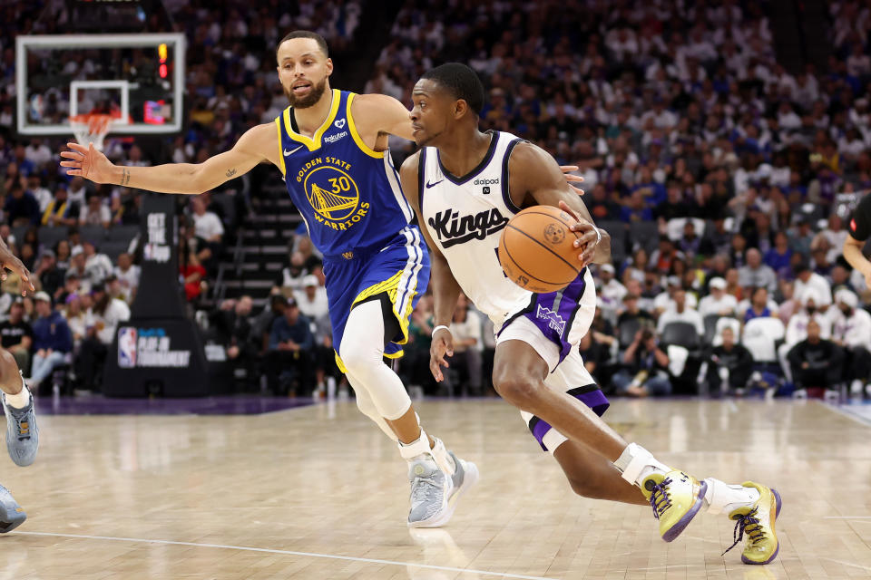 SACRAMENTO, CALIFORNIA - APRIL 16: De'Aaron Fox #5 of the Sacramento Kings is guarded by Stephen Curry #30 of the Golden State Warriors in the second half during the Play-In Tournament at Golden 1 Center on April 16, 2024 in Sacramento, California. NOTE TO USER: User expressly acknowledges and agrees that, by downloading and or using this photograph, User is consenting to the terms and conditions of the Getty Images License Agreement. (Photo by Ezra Shaw/Getty Images)