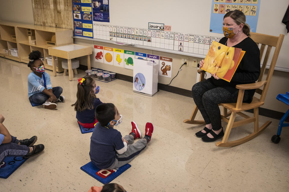 FILE - In this Jan. 11, 2021 file photo, pre-kindergarten teacher Angela Panush reads a story to her students at Dawes Elementary in Chicago. Chicago Public Schools should allow students back into classrooms in no more than 100 facilities and then gradually reopen others, an organization of school principals proposed Wednesday, Jan. 27, 2021, saying most of them doubt the nation's third-largest school district can safely handle a mass reopening. (Ashlee Rezin Garcia/Chicago Sun-Times via AP, Pool File)