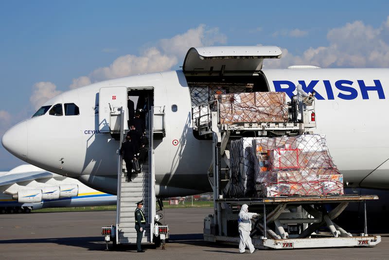 Workers unload a shipment of medical supplies from Turkey intended to combat the spread of the coronavirus disease (COVID-19), at Almaty International Airport
