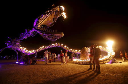 People gather at the art installation Serpent Mother during the Burning Man 2015 "Carnival of Mirrors" arts and music festival in the Black Rock Desert of Nevada, September 1, 2015. REUTERS/Jim Urquhart