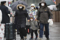 Chinese tourists wear masks at Ginza shopping district in Tokyo, Tuesday, Jan. 28, 2020. China has confirmed more than 4,500 cases of a new virus. Most have been in the central city of Wuhan where the outbreak began in December. More than 45 cases have been confirmed in other places with nearly all of them involving Chinese tourists or people who visited Wuhan recently. (AP Photo/Koji Sasahara)