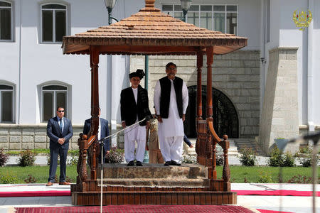 Afghanistan's President Ashraf Ghani (L) and Pakistani Prime Minister Shahid Khaqan Abbasi inspect the honor guard at the presidential palace in Kabul, Afghanistan April 6, 2018. Presidential palace/ Handout via REUTERS