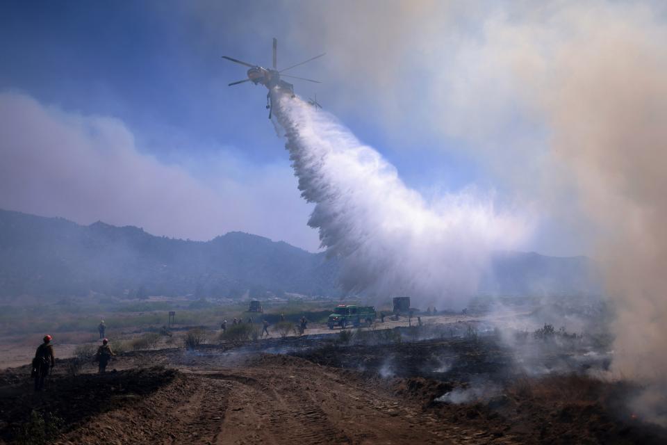 Air support drops water as the Post Fire burns through Castaic, California, June 16, 2024. The fire has grown to 12,265 acres, and continues to move southeast of Pyramid Lake, according to the US Department of Agriculture Forest Service at Angeles National Forest.