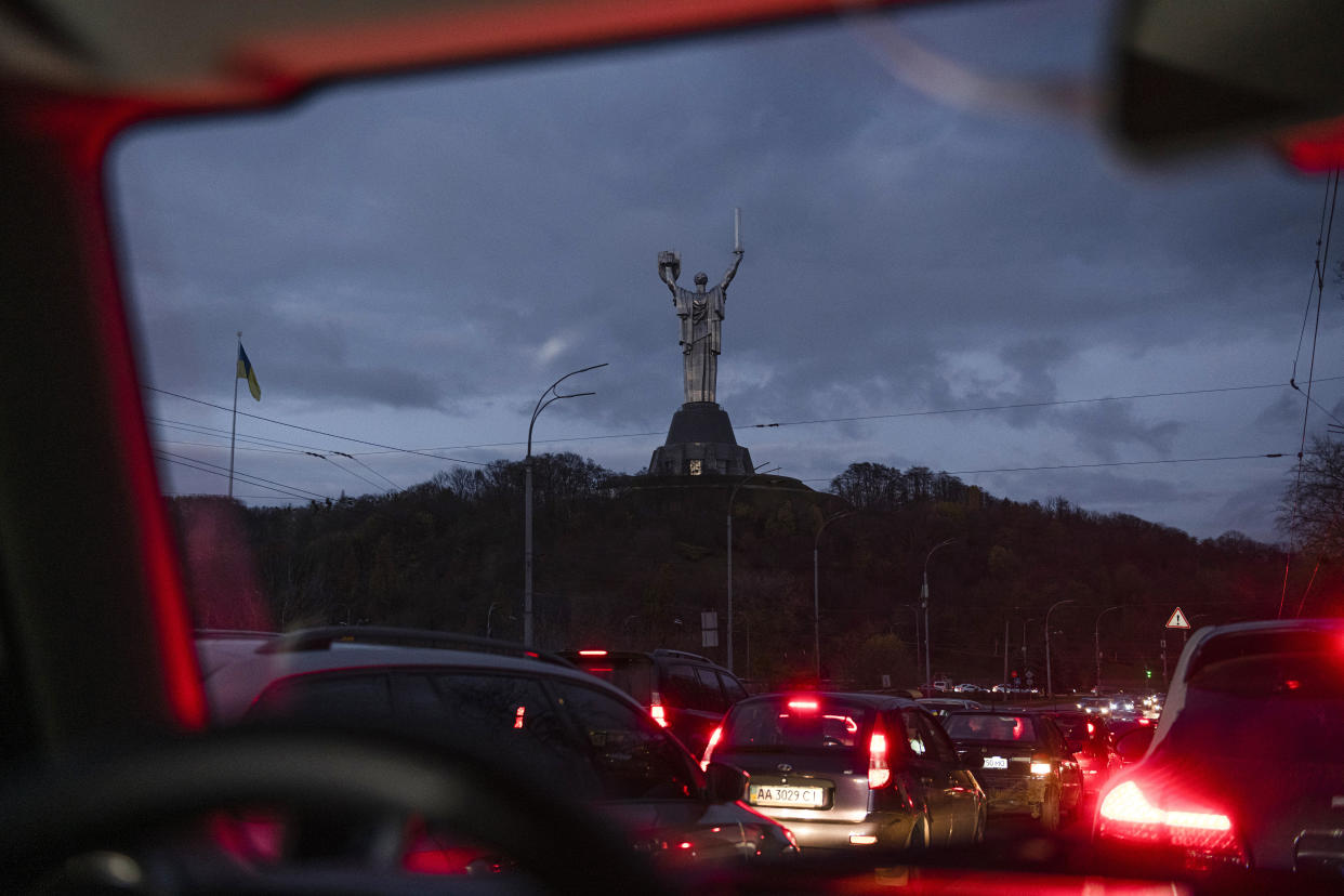 FILE - Cars move in the dark, with the Motherland Monument in the background, during a blackout in Kyiv, Ukraine, Friday, Nov. 11, 2022. The situation in Ukraine's capital, Kyiv, and other major cities has deteriorated drastically following the largest missile attack on the country's power grid on Tuesday, Nov. 15, 2022. Ukrainian state-owned grid operator Ukrenergo reported that 40% of Ukrainians were experiencing difficulties, due to damage to at least 15 major energy hubs across the country. (AP Photo/Andrew Kravchenko, File)