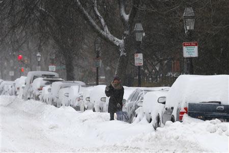 A driver works to dig a car out of the snow during a winter nor'easter snow storm in Boston, Massachusetts January 3, 2014. REUTERS/Brian Snyder