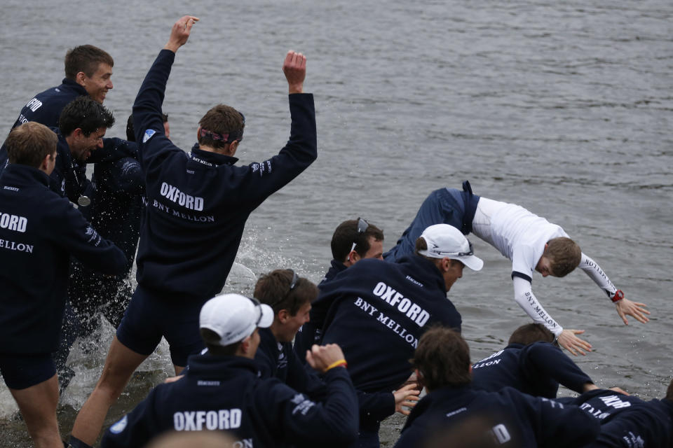 Members of the Oxford University rowing boat crew throw their cox Laurence Harvet into the River Thames as they celebrate their win against Cambridge University at the end of their 160th annual Boat Race on the River Thames, London, Sunday, April 6, 2014. The traditional boat race is a hotly contested point of honor between Oxford and Cambridge universities, and Cambridge still leads the series 81-78, with one tie. (AP Photo/Sang Tan)