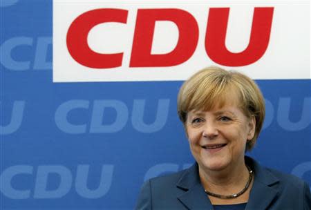 German Chancellor Angela Merkel and leader of the Christian Democratic Union party CDU stands in front of her party's logo before a CDU board meeting in Berlin September 16, 2013. REUTERS/Fabrizio Bensch